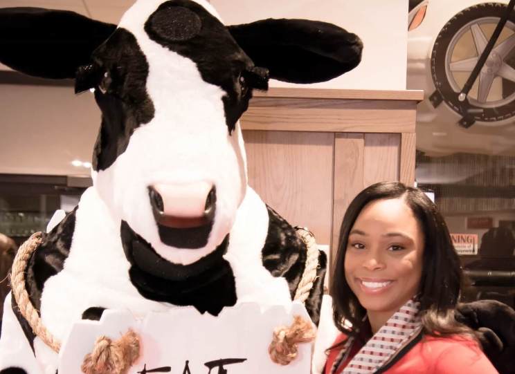 Tasha Fox posing with the Chick-fil-A cow mascot.