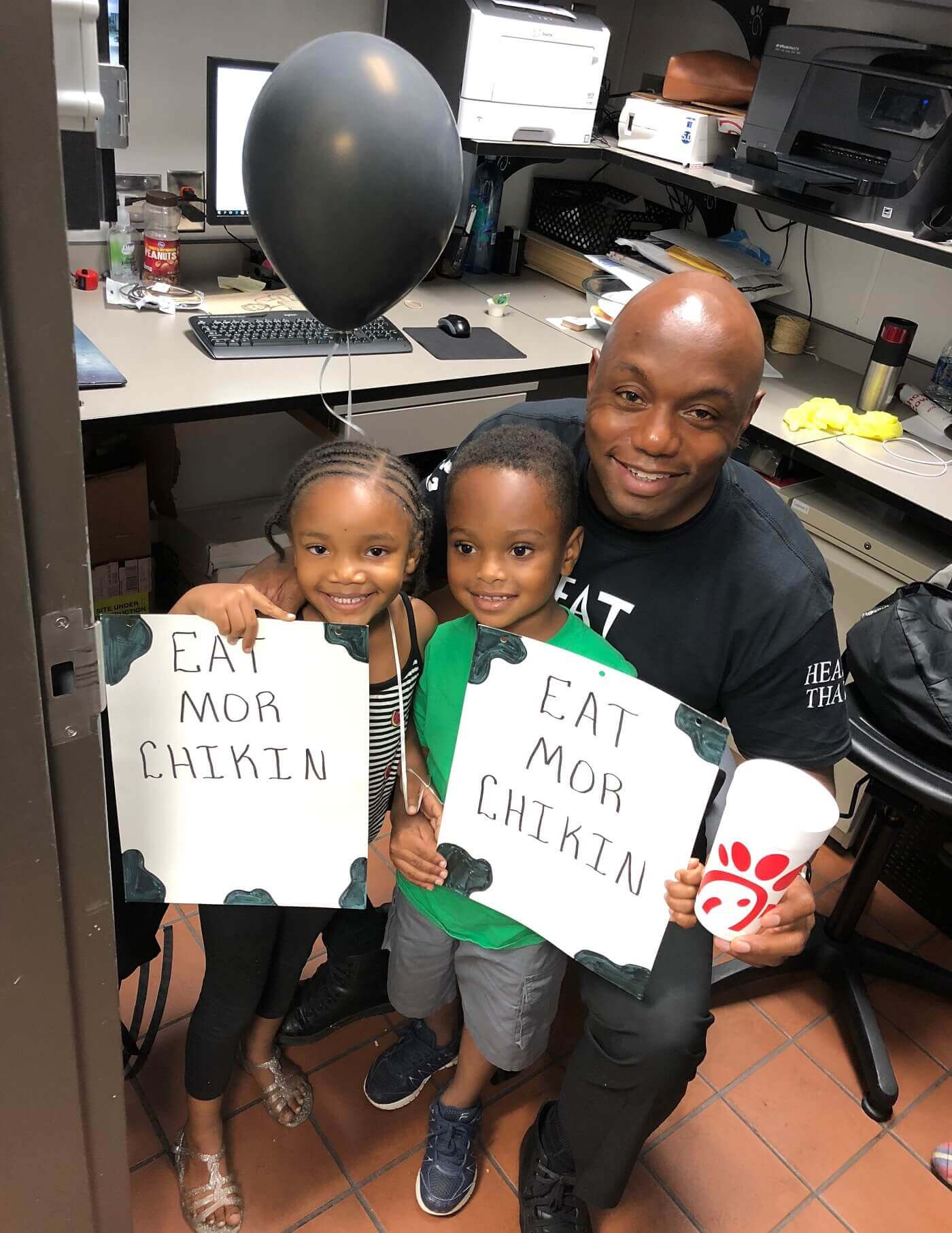 Chick-fil-A Operator Quincy with his two young children in his office.