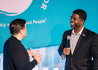 Two men talking on a stage.