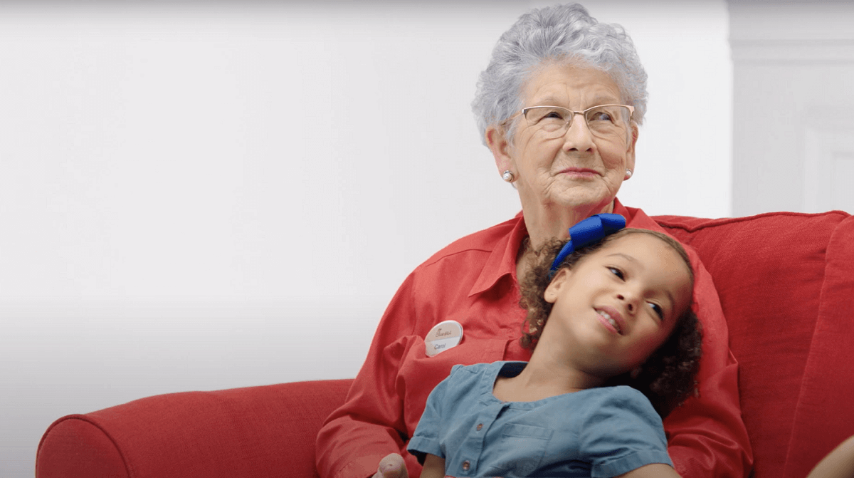 Employee "Ms. Carol" on a couch with child on her lap