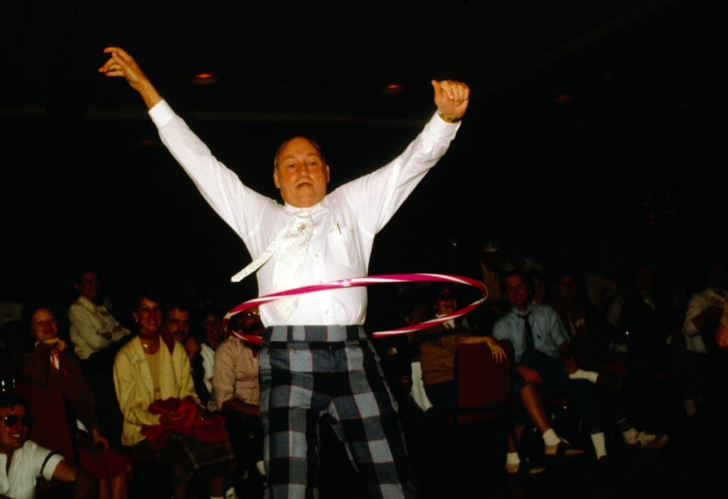 Truett Cathyhula hooping with a pink hoop in front of an audience.