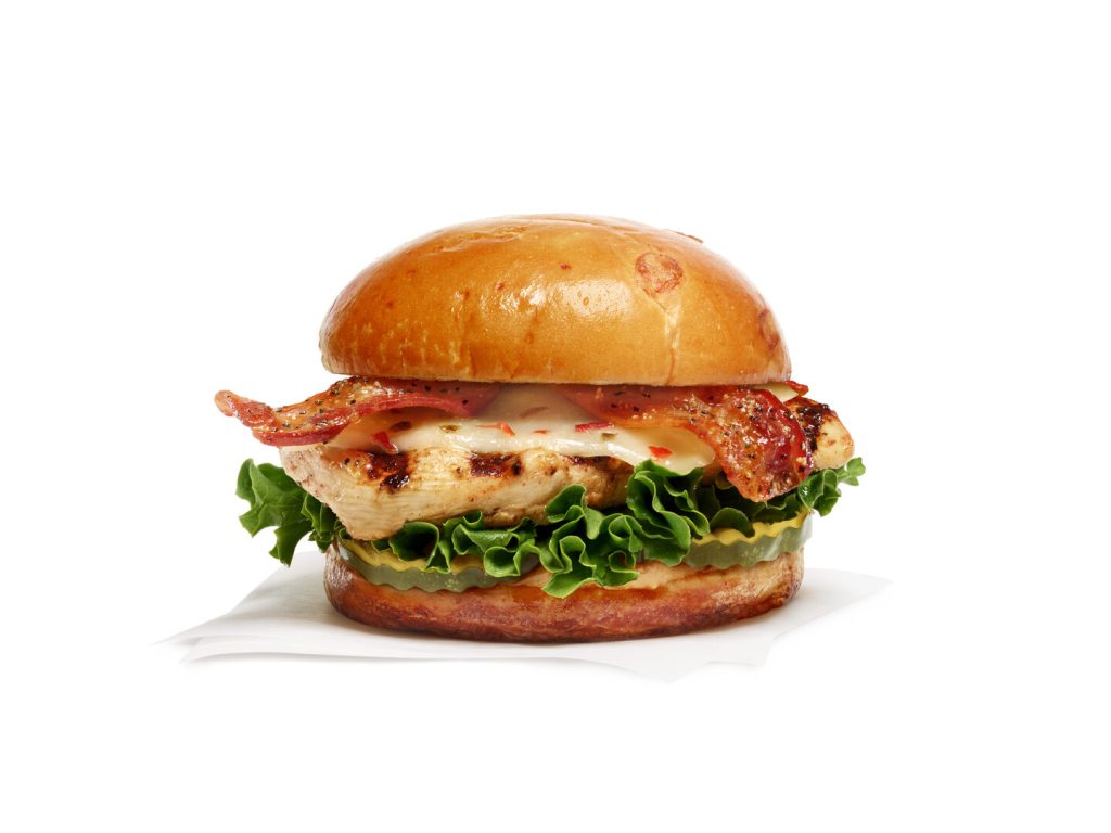 Grilled chicken sandwich on a toasted bun with maple pepper bacon, lettuce, pickles, and cheese.