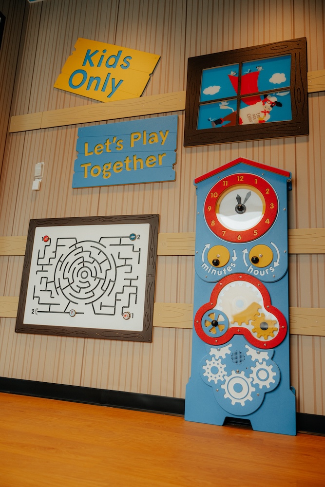 Children's play area decor with signs, a maze, and an interactive clock panel.