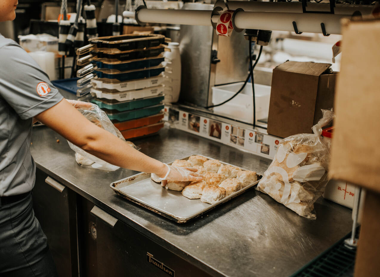 A Chick-fil-A team member packs biscuits into branded bags