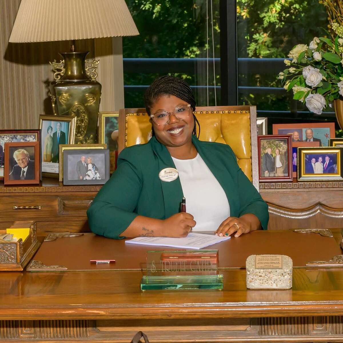 Chantay Bollinger sitting at a desk with photos behind her