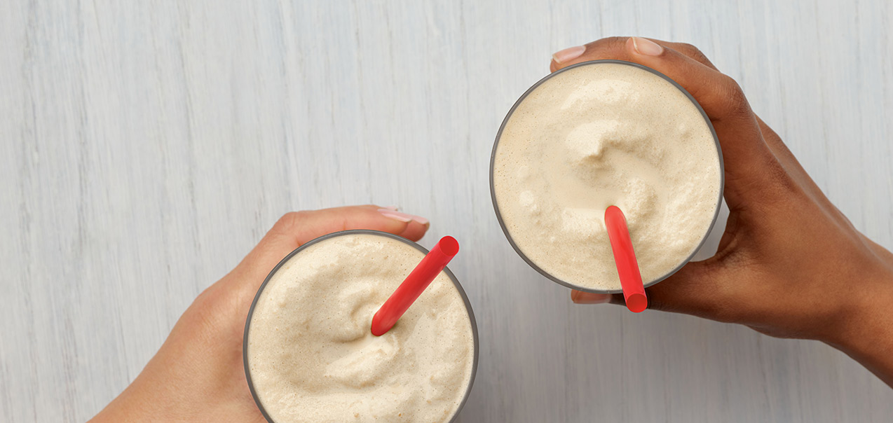 2 glasses with red straws of blend of cold-brewed coffee and classic vanilla Icedream® dessert