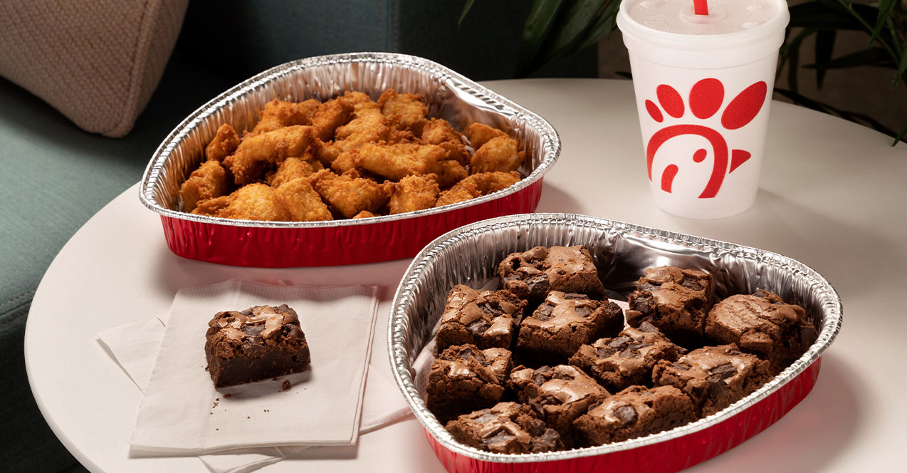 2 heart-shaped trays; one filled with brownies and one filled with nuggets