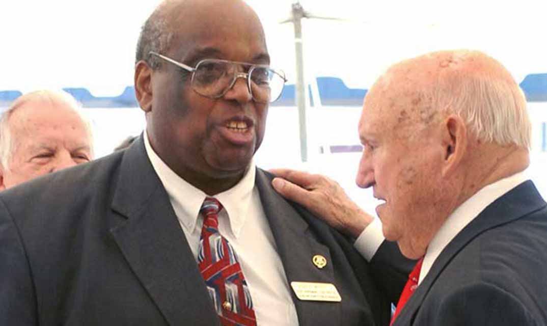 Eddie White and Truett Cathy talking at an event.