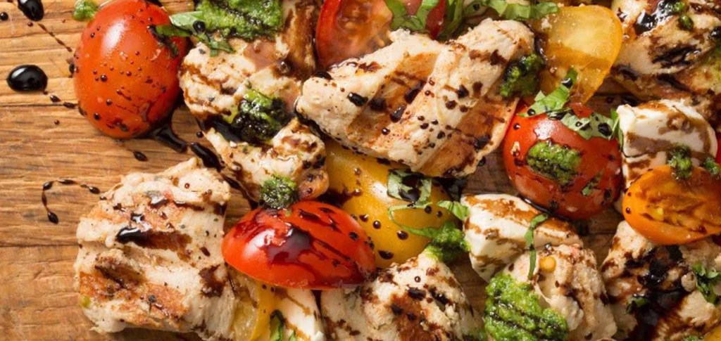Grilled Nuggets with slices of tomatoes and basil with balsamic glaze drizzled over it
