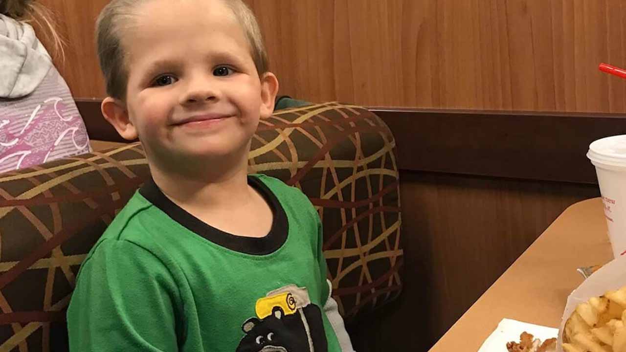 A little boy sitting at a Chick-fil-A booth smiling