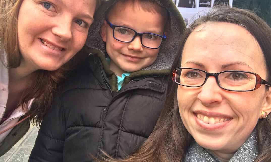 Young customer and his mother sitting posing with a Chick-fil-A employee.