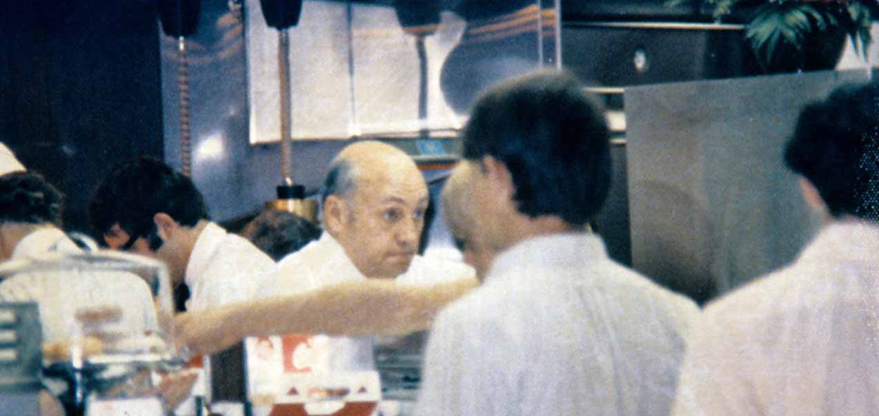 Truett Cathy behind a restaurant counter