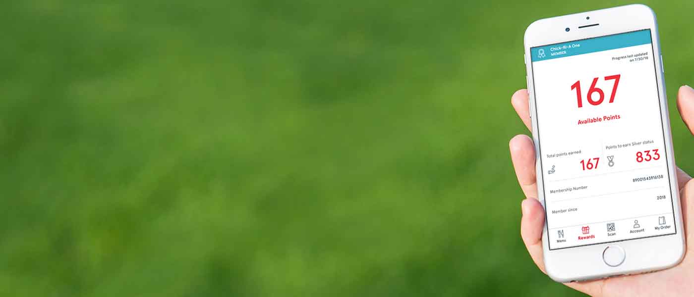 Person holding a smartphone displaying the Chick-fil-A app