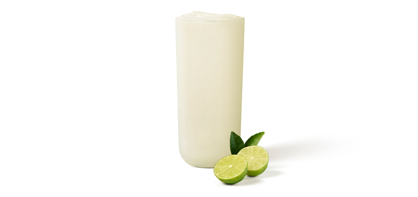 Frozen Key Lime Lemonade in a glass with a sliced fresh key lime