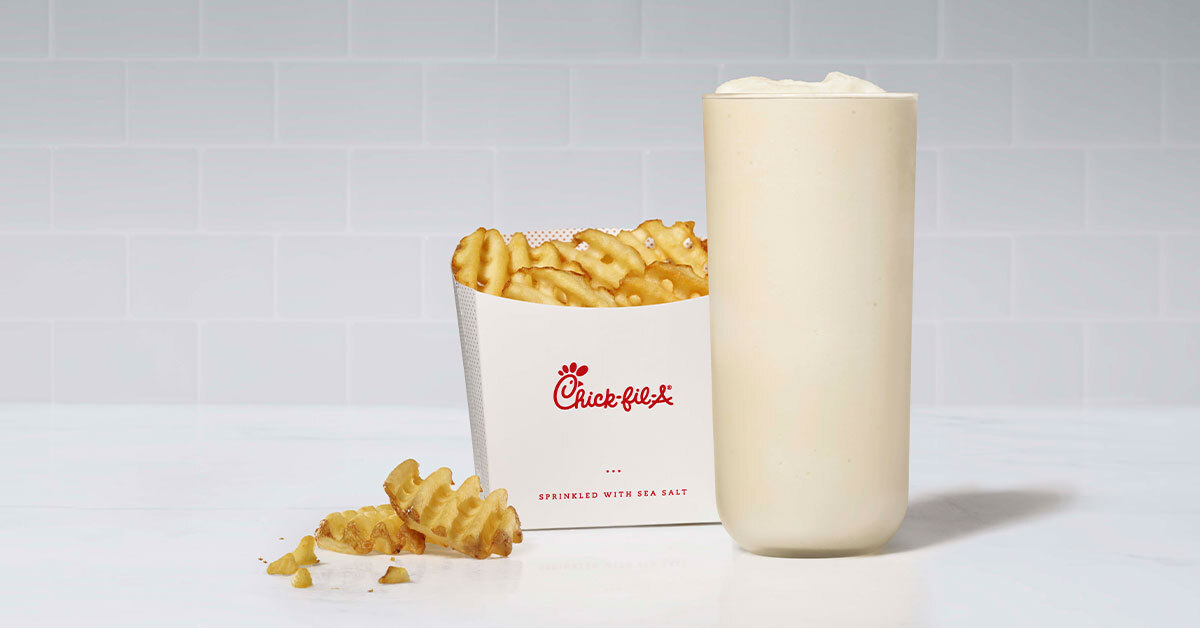 A glass of Mango Passion Frosted Lemonade with waffle fries next to it.