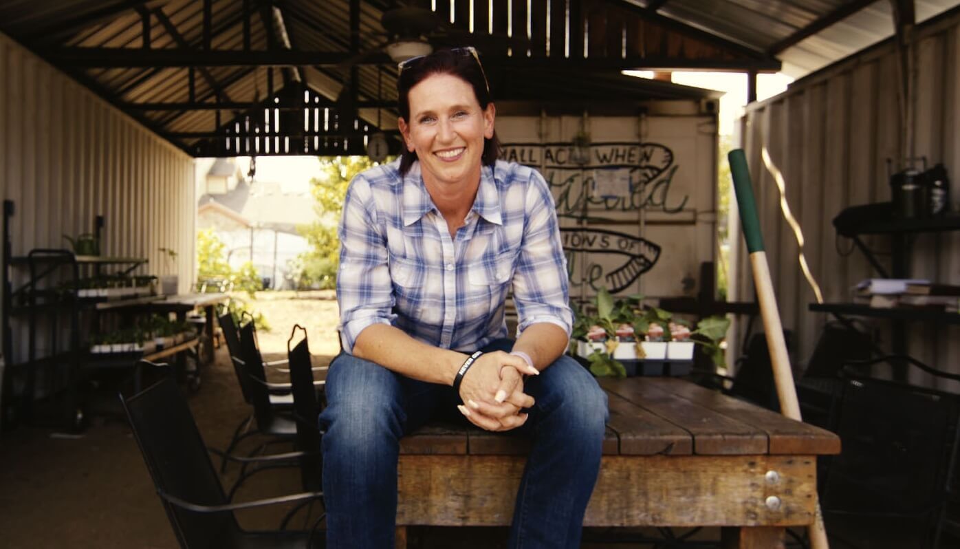 Vanessa Bales sitting on a table in barn.