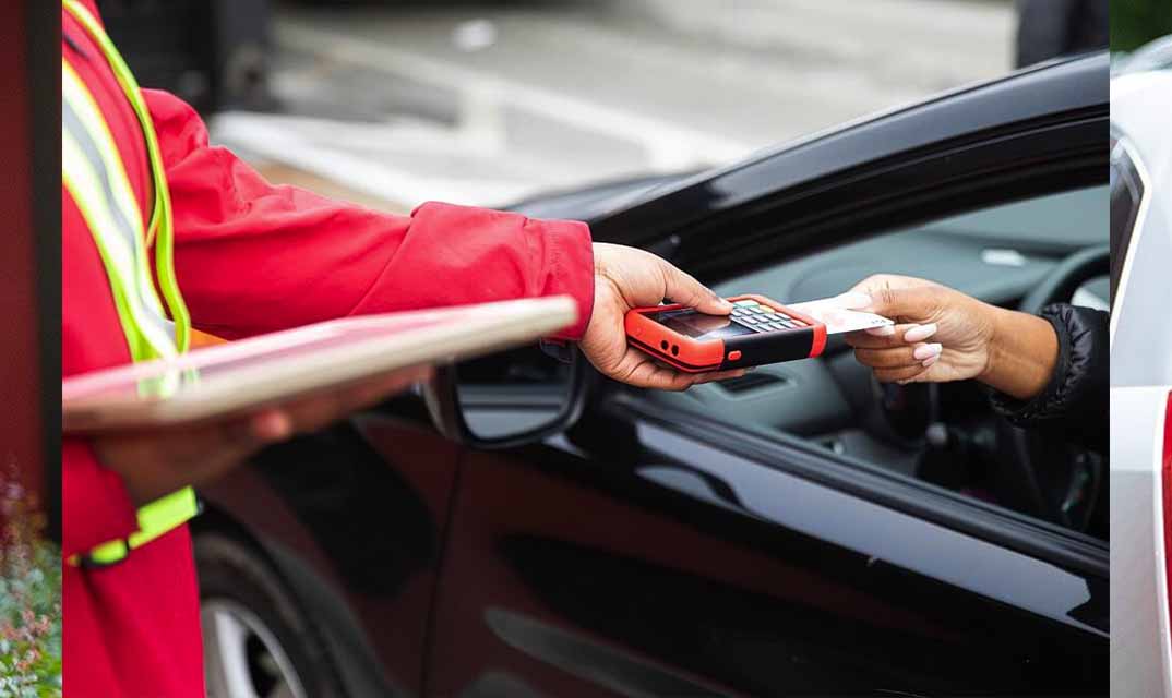 A Chick-fil-A team member takes a payment from a customer
