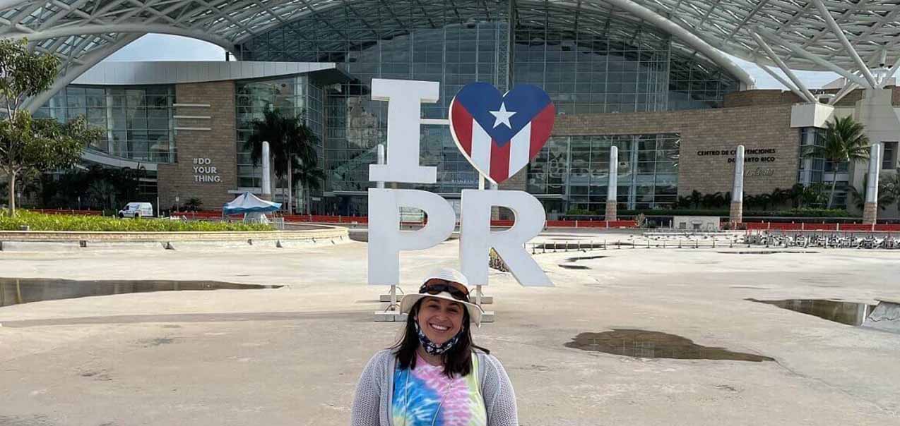 Caitlin Chavez in front of "I ❤️ PR" sign at the Puerto Rico Convention Center.