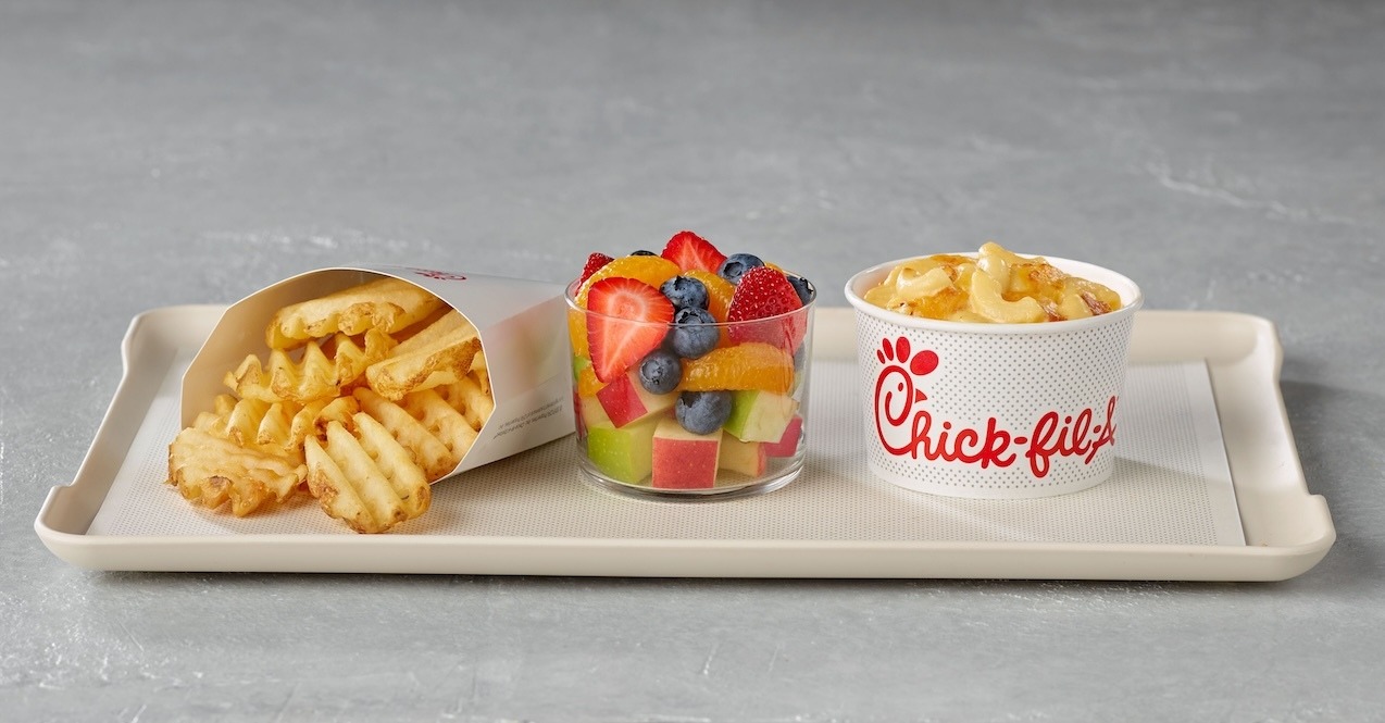 Chick-fil-A sides on a tray: Waffle fries, fruit salad, and macaroni and cheese.