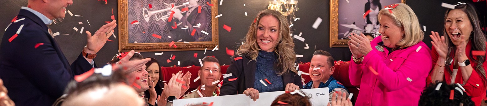 Group of people celebrating indoors with confetti and balloons.