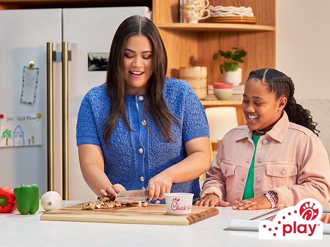 A mother and daughter in their kitchen prepping food.
