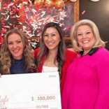 Three women smiling at celebration.