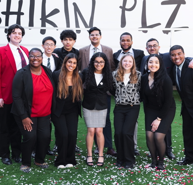 2025 Scholars in formal attire posing in front of sign