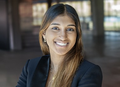 Headshot of Ava with a blurred indoor background.