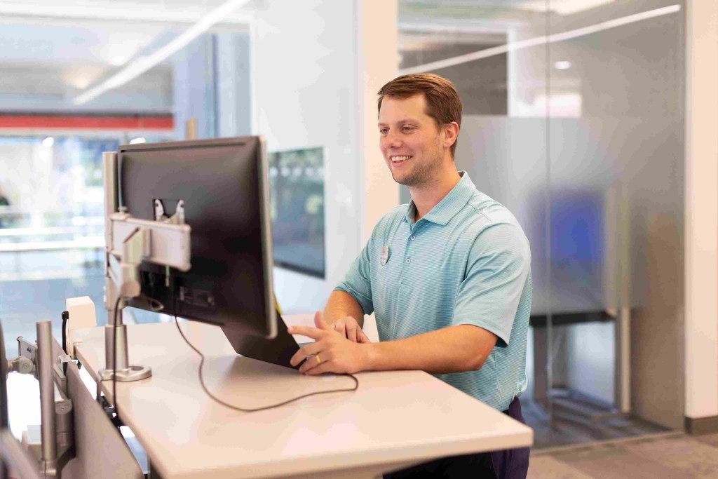 Corporate team member working at a standing desk and computer in a modern office at Chick-fil-A Support Center.