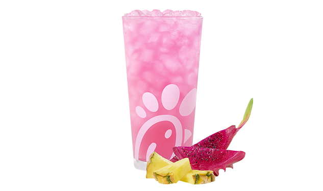 A glass of a Pineapple Dragonfruit Lemonade accompanied by slices of pineapple and dragon fruit.