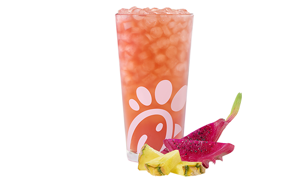 A glass of a Pineapple Dragonfruit Sunjoy® by slices of pineapple and dragon fruit.