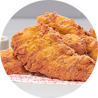 A closeup of Chick-fil-A Chick-n-Strips® on red and white paper