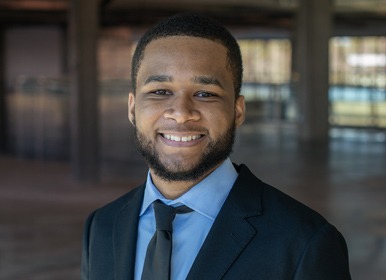 Headshot of Dajhon with a blurred indoor background.