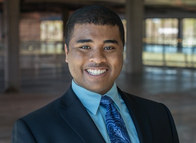 Headshot of James with a blurred indoor background.