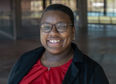 Headshot of MaCalaah with a blurred indoor background.