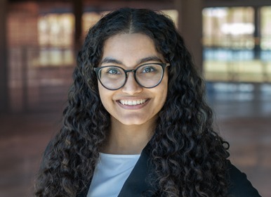 Headshot of Osheen with a blurred indoor background.