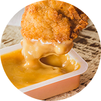 A Chick-fil-A Chick-n-Strip® being dipped into Chick-fil-A® Sauce