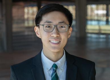Headshot of Ray with a blurred indoor background.