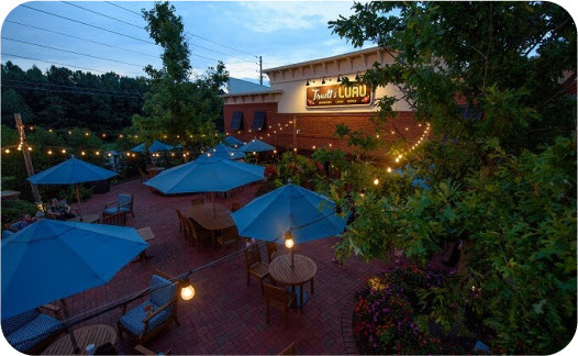 Exterior view of Truett's Luau Hawaiian-themed restaurant in Fayetteville, Georgia, featuring tropical landscaping and tiki-style architectural elements