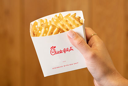 A person holding a package of Chick-fil-A Waffle Potato Fries®