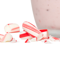 Broken candy canes next to a Peppermint shake.