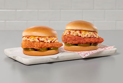 Two Honey Pepper Pimento Chicken Sandwiches on a serving board