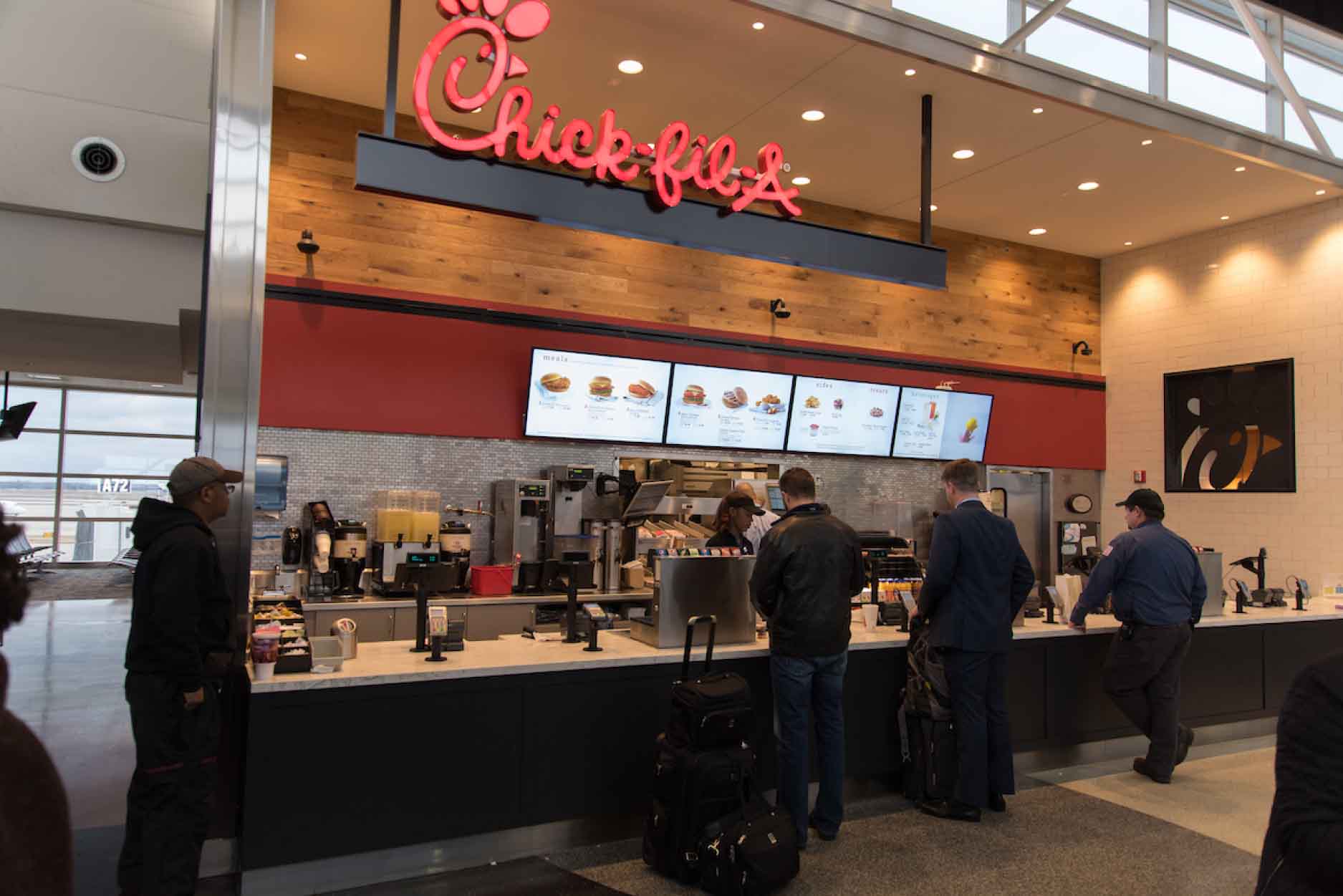Customers ordering at the counter of a Chick-fil-A licensing location
