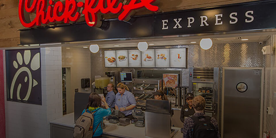 Customers ordering at the counter of a Chick-fil-A licensing location