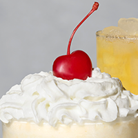 Whipped cream and a cherry on top of a Peach Milkshake
