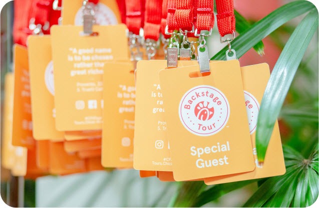 Orange Chick-fil-A backstage tour badges with red lanyards and "Special Guest" text.