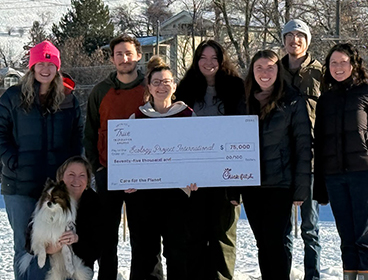 A group of people from Ecology Project International standing together and holding a large check