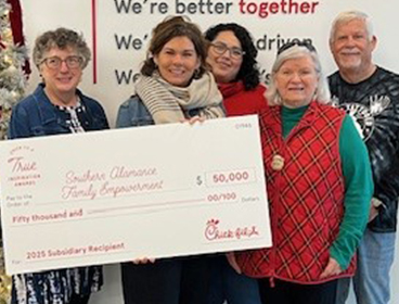 People from Southern Alamance Family Empowerment standing together holding a large check and smiling