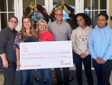 People from the Sheridan House Family Ministries standing together smiling and holding a large check