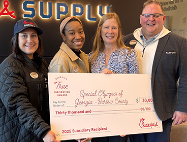 People from Special Olympics of Georgia - Bartow County standing together holding a large check and smiling
